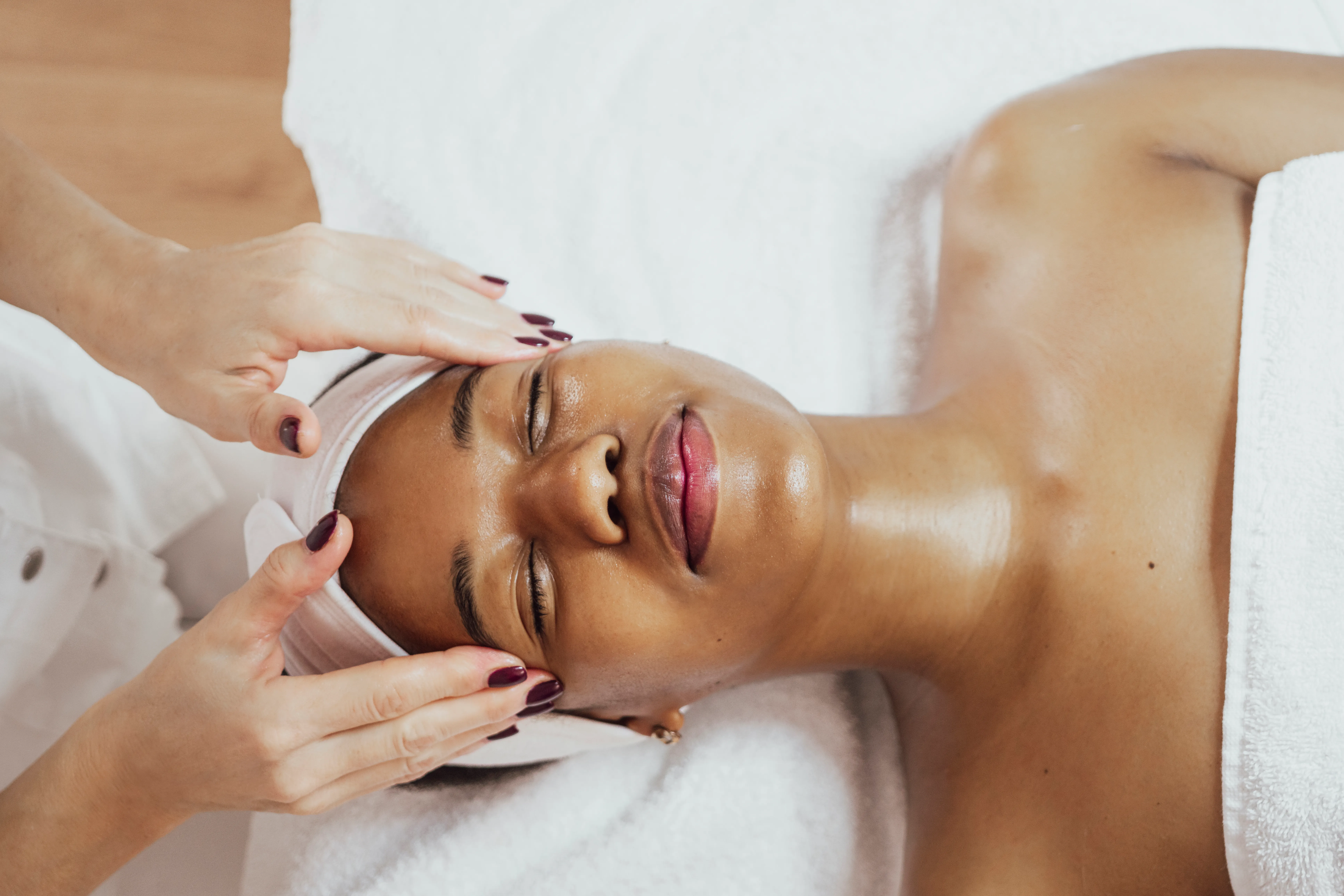 Hands performing a gentle facial massage